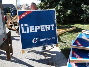 Former Alberta cabinet minister Ron Liepert, cleans up his signs in Calgary on Tuesday after his victory in Signall Hill.