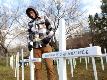 Volunteers like Max Smith help put up crosses at the Field of Crosses project on Oct. 24, 2015.