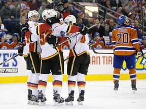 Calgary Flames celebrate a goal as Edmonton Oilers' Luke Gazdic (20), right, skates by during first period NHL action in Edmonton, Alta., on Saturday, Oct. 31, 2015.