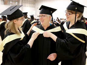 Juanita Marshall, 55, gets ready to graduate with a degree in social work from at the University of Calgary on Nov. 12, 2015 along with her two daughters Natashia Marshall, 27, left and Sarah Jane Marshall, 30.