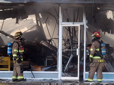 Members of the Calgary Fire Department looked for hot spots after the roof collapsed in the Billingsgate Seafood Market during a two alarm fire at the Stadium Shopping Centre on Nov. 12, 2015. At least four businesses were heavily damaged by fire while others in the mall sustained smoke and water damage.