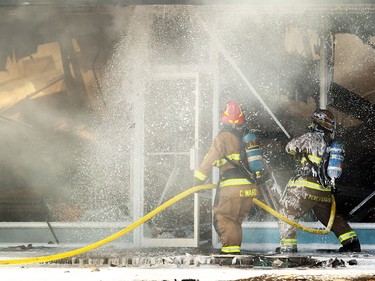 Members of the Calgary Fire Department worked to douse hot spots after the roof collapsed in the Billingsgate Seafood Market during a two alarm fire at the Stadium Shopping Centre on Nov. 12, 2015. At least four businesses were heavily damaged by fire while others in the mall sustained smoke and water damage.