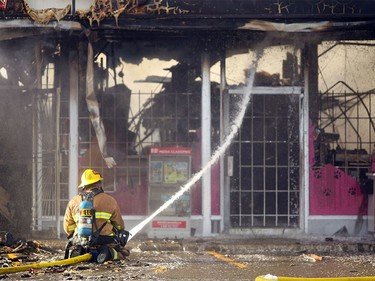 FILE PHOTO: Members of the Calgary Fire Department worked to douse hot spots after the roof collapsed in the Cat House during a two alarm fire at the Stadium Shopping Centre on Nov. 12, 2015.