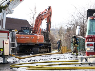 An excavator was brought in to help as members of the Calgary Fire Department worked to douse hot spots after the roof collapsed during a two alarm fire at the Stadium Shopping Centre on Nov. 12, 2015.