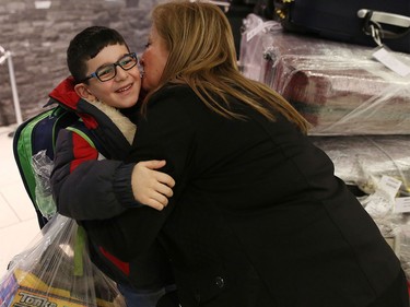 Syrian refugees are greeted by family members as they arrive at the the Calgary International Airport on Nov. 23, 2015.