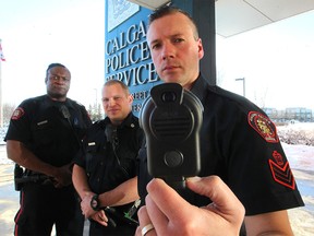 Calgary Police Service members, from right to left, Staff Sgt. Todd Robertson, Cst. Trevor Marquis and Cst. Ottis Scott-Sabula showed off the latest body worn cameras to be used by the Calgary Police Service following a media event at the Westwinds head quarters on Nov. 26, 2015.