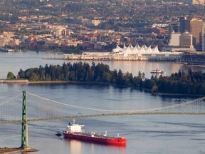 A oil tanker is guided by tug boats as it goes under the Lions Gate Bridge. The Liberals are not opposed to the Kinder Morgan pipeline expansion which would mean a lot more tankers on this waterway. But they will insist on a tougher environmental review.
