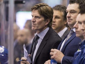Toronto Maple Leafs head coach Mike Babcock, left, stands on the bench during first period pre-season NHL hockey action against Buffalo Sabres in Toronto on Friday September 25, 2015.THE CANADIAN PRESS/Chris Young