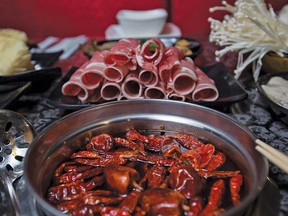 1 Pot's szechuan spicy soup with sliced lamb rolls.