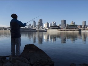 A man fishes off the shores of the St. Lawrence River earlier this week, before the City of Montreal began a massive raw sewage dump to accommodate repairs to infrastructure.