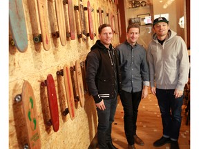 PJ L'Heureux, centre, with associates Mike Grimes, left, and Pete Emes next to a wall of vintage skateboards at his new pub, Home & Away, in the former Moxies at 1331 17th Avenue S.W.