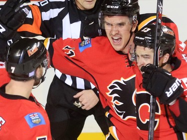 Calgary Flames TJ Brodie, Mikael Backlund and Johnny Gaudreau celebrate after Backlund's overtime winning goal on the Flyers' Michal Neuwirth winning the game 2-1 at the Scotiabank Saddledome on Thursday Nov. 5, 2015