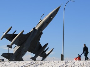 An RCAF member and his son walk towards a CF-5A Freedom Fighter at the 2015 Remembrance Day service at the Military Museums in Calgary.