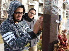 Steven Sharda's brothers Jaspreet, left, and Navdeep Sharda read notes of condolence on a memorial to Steven near where he was shot. Crime Stoppers conducted a re-enactment at the site Friday to help generate more leads in his murder.