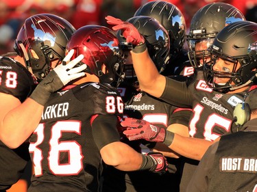 The Calgary Stampeders congratulate Anthony Parker on a 2 point conversion on Eric Rogers' touchdown during the first half of the CFL's West Division semifinal against the B.C. Lions at McMahon Stadium on Sunday November 15, 2015