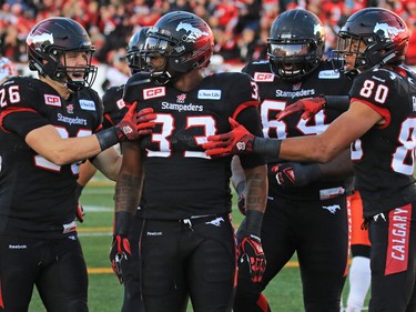 The Calgary Stampeders congratulate running back Jerome Messam after his touchdown during the first half of the CFL's West Division semifinal against the B.C. Lions at McMahon Stadium.