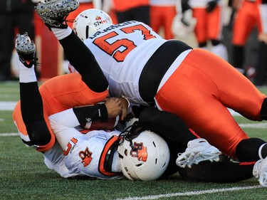 The Calgary Stampeders Frank Beltre with the B.C. Lions' Tommie Draheim on top sacks B.C. Lions quarterback Jonathan Jennings during the first half of the CFL's West Division semifinal at McMahon Stadium on Sunday November 15, 2015
