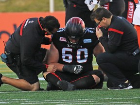 Calgary Stampeders offensive lineman Shane Bergman is helped after being in injured in the CFL west semi-final against the B.C. Lions on Sunday November 15, 2015.