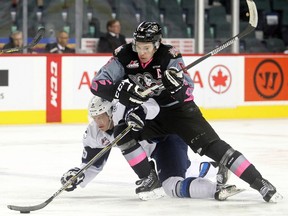 Calgary Hitmen captain Colby Harmsworth brings down Mason McCarty of the Saskatoon Blades in the third period at the Scotiabank Saddledome on Sunday.