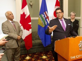 Mayor Naheed Nenshi speaks Tuesday, Nov. 24 about plans for bringing Syrian refugees to the city in a press briefing at City Hall. Behind him are Katie Black, director of Community & Neighbourhood Services and Fariborz Birjandian, CEO of Calgary Catholic Immigration Society.