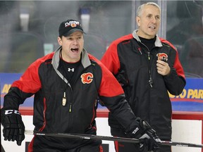 Calgary Flames head coach Bob Hartley and assistant coach Martin Gelinas shout instructions during practice at the Saddledome on Monday.