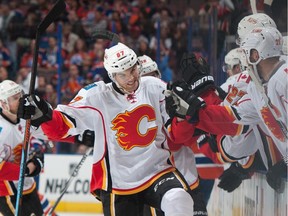 Michael Frolik of the Calgary Flames is congratulated by teammates on the bench after scoring the game-winning goal against the Edmonton Oilers on Saturday. His shot from behind the goal-line beat Cam Talbot and might be the kick-start of good karma the Flames need to get their season going.