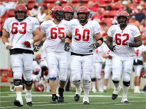 Offensive linemen Pierre Lavertu, 63; Dan Federkeil, 65; Shane Bergman, 60, Spencer Wilson, 50 and Edwin Harrison, 62; head out onto the field as the Calgary Stampeders hosted their training camp annual intra-squad game on Sunday, June 7, 2015 at McMahon Stadium.