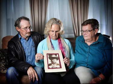 The children of David Day, who was killed in the CIL Explosives Plant explosion on April 21, 1975, pose with his photo, from left, Tom Day, Lorraine Barrett and Jeanette Cuthbert.