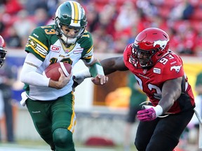 Calgary Stampeders Micah Johnson, right, runs to tackle Edmonton Eskimos quarterback Mike Reilly during their game at McMahon Stadium in Calgary on October 10, 2015.