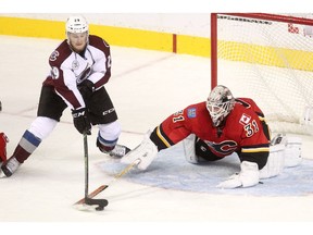 Calgary Flames goalie Karri Ramo, right, blocks a shot from Colorado Avalanche Nathan MacKinnon during pre-season action at the Scotiabank Saddledome Sept. 29, 2015.