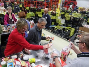 Volunteers help pack hampers at the Calgary Inter-Faith Food Bank, as a new report found that food bank usage has spiked by 23 per cent in Calgary and Alberta over the past year.