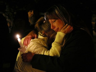 Grandmother of missing two-year-old Hailey Dunbar-Blanchette Terry Dunbar, left, was hugged by a family friend as the crowd reacted to the news of the cancellation of an amber alert during a candlelight vigil on September 15, 2015. A member of the RCMP Victim Services unit was the person to inform the crowd that human remains believed to be Hailey's had been found.
