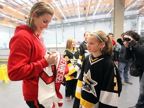Canadian women's hockey legend and Calgary Inferno star Hayley Wickenheiser signs a jersey for Pee Wee 2A player Rylee Mepham, from Ardossan, Alta., during Wickfest at WinSport on Saturday. Players from 99 teams converged on the city for the annual event aimed at growing girls hockey, while the Inferno played twice against the Brampton Thunder and won both in Canadian Women's Hockey League action.