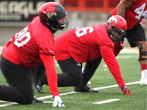 New Calgary Stampeders defensive lineman Uriah Grant Jr., right, lines up during practice on Thursday. His father, Uriah Grant St. was a two-time world cruiserweight boxing champion.