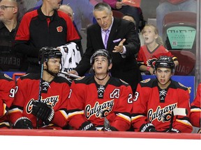 Calgary Flames head coach Bob Hartley gives instructions to players, from left, right winger Michael Frolik, centre Sean Monahan and left winger Johnny Gaudreau during a game last month. Monahan is struggling to find the form that had him making crucial plays all over the ice last season.