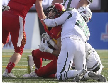 Calgary Dinos' Brett Blaszko gets tacken down by Sask Huskies Spencer Kreiger and Chris Friesen during playoff action against the at McMahon Stadium in Calgary, on November 7, 2015. -