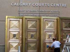 The brass doors are cleaned in front of the Calgary Courts Centre on Thursday, April 23, 2014.