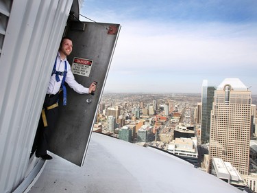 Calgary Tower Controls Specialist Dave Hiemstra peered out a door on the roof of the Calgary Tower on April 21, 2015. Hiemstra is responsible for programming the LED light display show on the Calgary Tower.