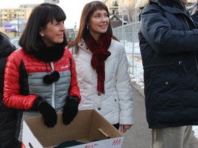 Lucy Miller, CEO and President of United Way of Calgary and Area with Karen Young, COO of United Way of Calgary and Area handing out winter gloves.