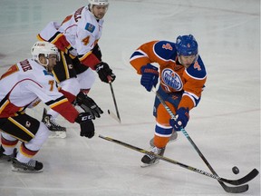 Calgary Flames defenceman T.J. Brodie, left, and Kris Russell look to foil a Taylor Hall rush in Edmonton on Saturday night.