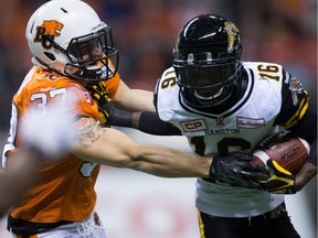 Hamilton Tiger-Cats' Brandon Banks, right, fights off B.C. Lions' Eric Fraser on a kick return during the first half of a CFL football game in Vancouver, B.C., on Friday October 23, 2015.