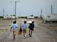 Children walk home after being dropped off by their schoolbus in the FEMA Diamond travel trailer park May 22, 2008 in Port Sulphur, Louisiana. Living through the hurricane had lasting effects on children.