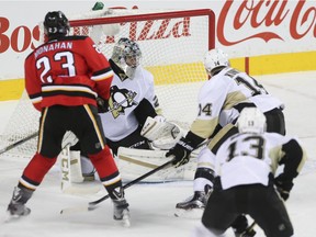 Pittsburg Penguins goalie Marc-Andre Fleury, centre, fails to stop a goal by Flames left winger Jonny Gaudreau at the Scotiabank Saddledome in Calgary on Saturday, Nov. 7, 2015.