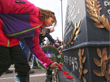Calgarians place poppies on the cenotaph at the Military Museums after the 2015 Remembrance Day ceremony.