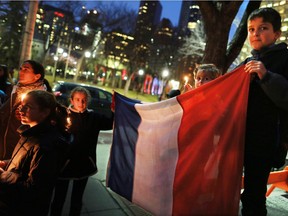 The De Fosseux family from Paris was among about 100 people who attended a candlelight vigil for the victims of the terrorist attack in Paris. The vigil took place outside City Hall in Calgary on Saturday night November 14, 2015.