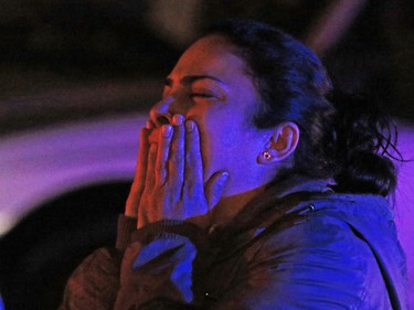 A distraught woman watches as police deal with a fatal shooting in a strip mall at 20th avenue and 52nd street S.E. on Saturday night November 14, 2015.