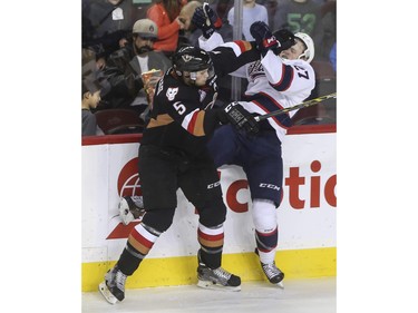 Calgary Hitmen's Keegan Kanzig gives Regina Pats' Austin Wagner a little poke to the face during second period action at the Saddledome in Calgary, on November 27, 2015.