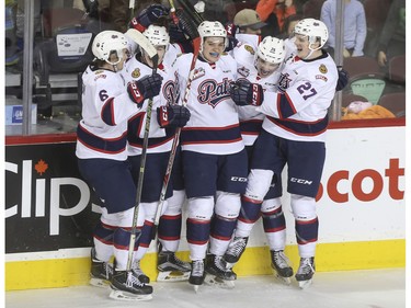 Regina Pats Adam Berg, centre, celebrates with his team after scoring a tie breaking goal against the Hitmen in the third period at the Saddledome in Calgary, on November 27, 2015.