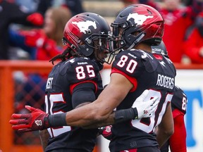 Calgary Stampeders' Joe West, left, celebrates his touchdown with teammate Eric Rogers during first half CFL football action against the Saskatchewan Roughriders in Calgary on Saturday.