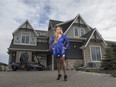 Grace Yan, realtor with Sotheby's International Realty Canada, in front of a multi-million dollar luxury home in the new Watermark development in Calgary. It’s a show home by New West Custom Homes.